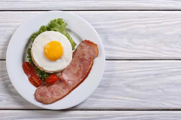 Fried egg with ham and cherry tomatoes on a table. — Stock Photo, Image
