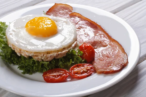 Rice cakes with eggs, bacon, lettuce and tomato on the table — Stock Photo, Image