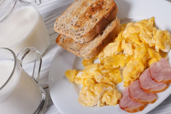 Scrambled eggs with bacon, toast and milk for breakfast — Stock Photo, Image