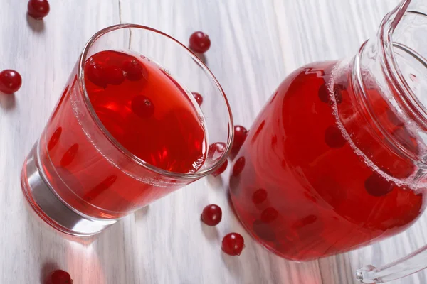 Клюквенный сок с ягодами в стакане на столе — стоковое фото