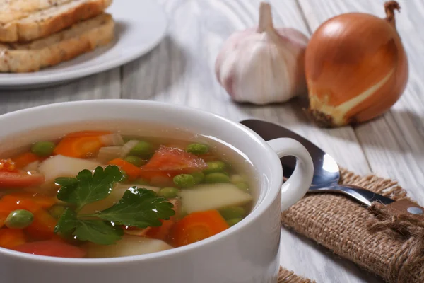 Sopa de legumes com ingredientes em uma mesa de madeira — Fotografia de Stock