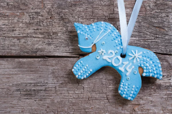 Рождественское печенье: синяя лошадь на фоне деревянных досок — стоковое фото