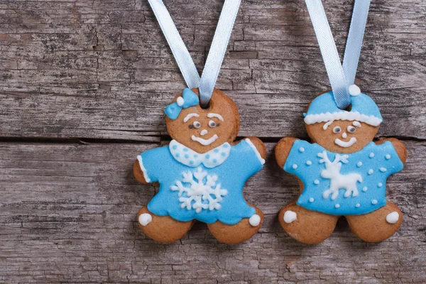 Two blue gingerbread men. Girl with bow and the boy in a hat — Stock Photo, Image