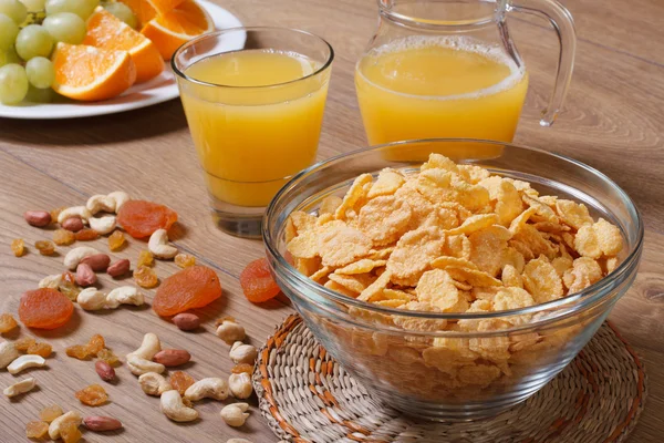 Cornflakes mit Trockenfrüchten und Orangensaft. — Stockfoto