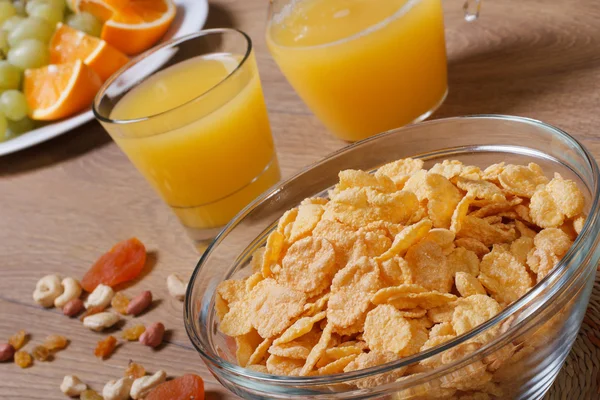 Cornflakes with fruits, nuts and orange juice — Stock Photo, Image