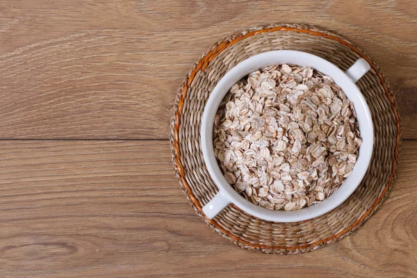 Dry oat flakes on a plate top view — Stock Photo, Image