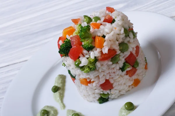 Rice with vegetables on a white plate with sauce — Stock Photo, Image