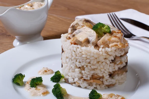 Riz aux champignons, brocoli et sauce à la crème sur une table . — Photo