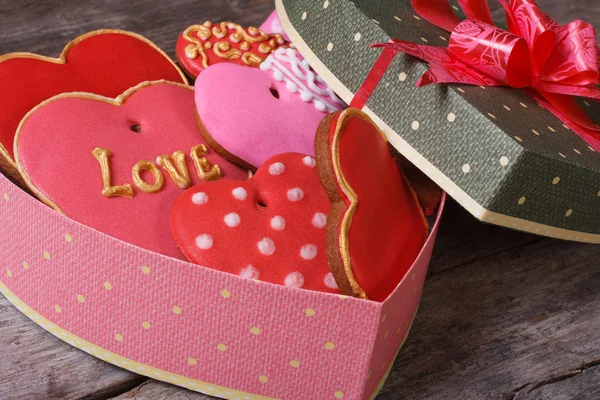Праздничная подарочная коробка в форме сердца со сладостями на столе — стоковое фото