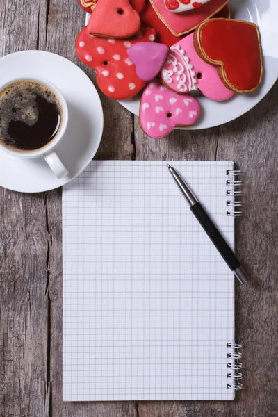 Café negro, galletas de colores y una nota sobre la mesa —  Fotos de Stock