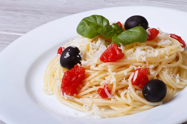 Pasta spaghetti with parmesan cheese and black olives and tomato — Stock Photo, Image