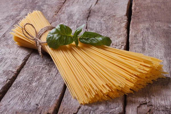 Špagety a bazalkou na staré tabulky closeup. — Stock fotografie
