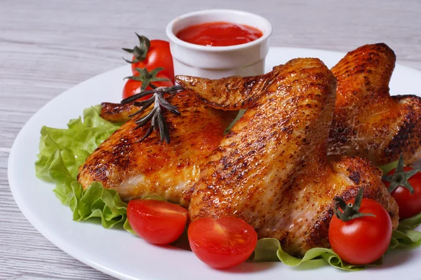 Kippenvleugels met cherry tomaten, sla en saus — Stockfoto