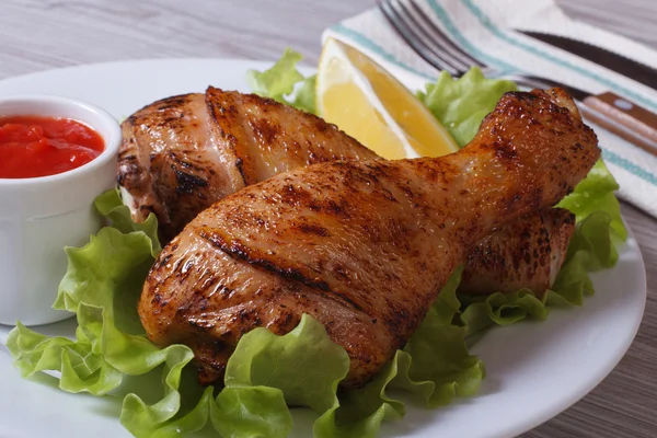 roasted chicken legs with salad, lemon and ketchup