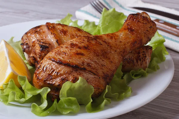 Roasted chicken legs with salad and a slice of lemon — Stock Photo, Image