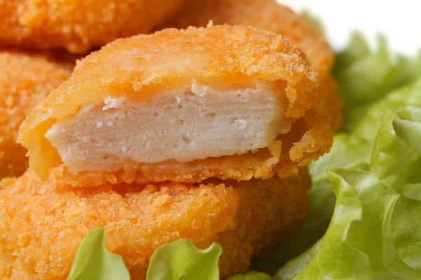 Nuggets z kurczaka świeże na zielonej sałaty z bliska. — Zdjęcie stockowe
