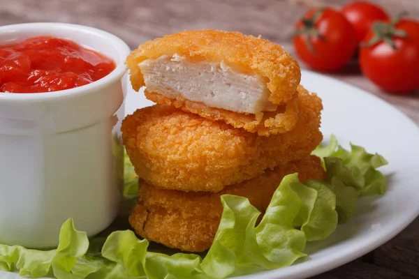 Kyckling nuggets, sallad och ketchup på en tallrik — Stockfoto