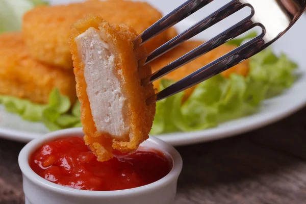 Pepitas de pollo empaladas en un tenedor y ketchup de cerca — Foto de Stock