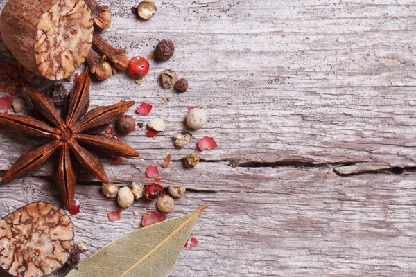 Nutmeg, anise, pepper and bay leaves on old wooden table. — Stock Photo, Image