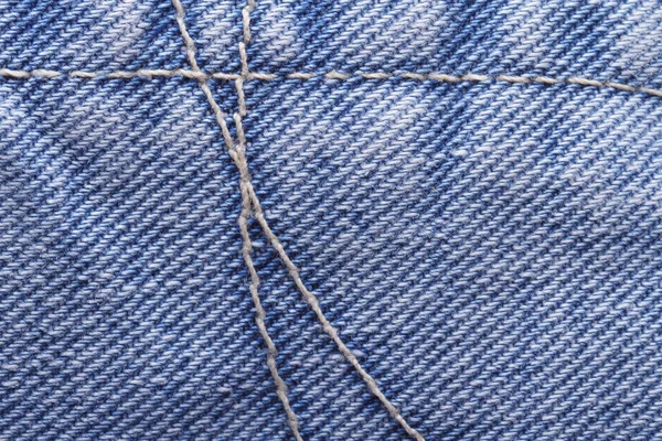 Seam yellow thread on blue jeans fabric close up. texture. — Stock Photo, Image