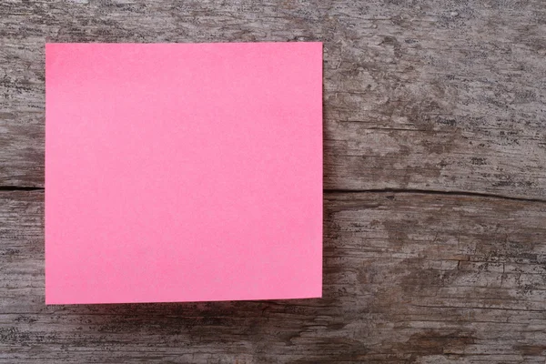 Etiqueta rosa em uma mesa de madeira velha — Fotografia de Stock