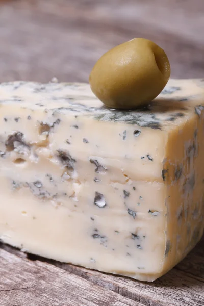 Blue cheese and olive on an old wooden table. vertical. — Stock Photo, Image