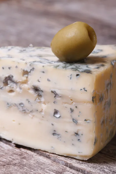 Formaggio blu e oliva su un vecchio tavolo di legno. verticale . — Foto Stock