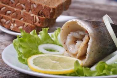 Salamura ringa balığı ile soğan salata, limon ve ekmek rulo