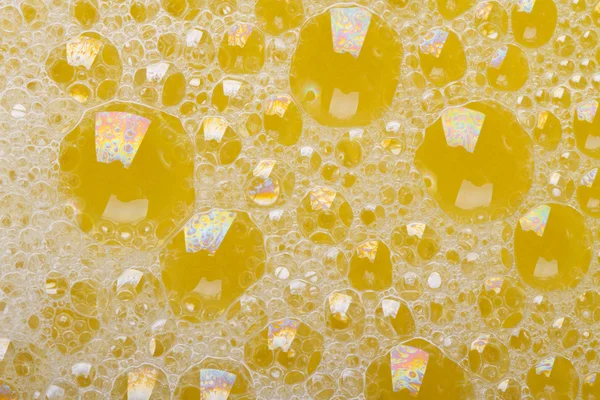 Hermoso fondo amarillo con burbujas de espuma de primer plano — Foto de Stock