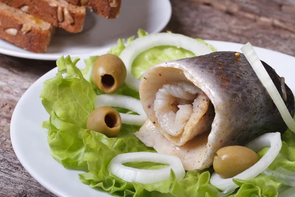 Herring roll with onion rings, olives and bread — Stock Photo, Image