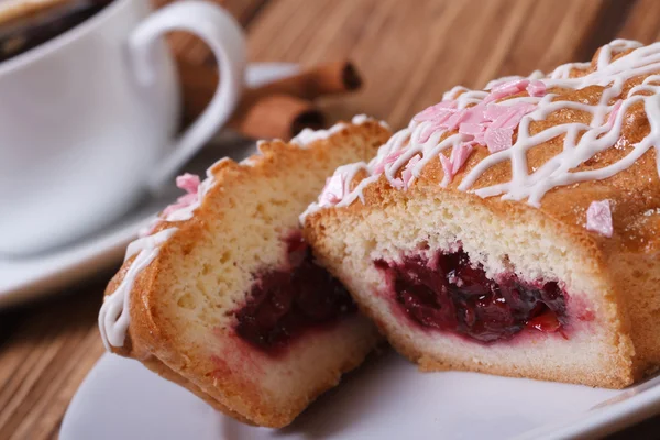 Skivad kaka med körsbär sylt närbild på bakgrund av kaffe — Stockfoto