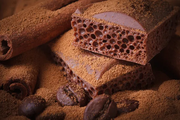 Chocolat aéré, grains de café et bâtonnets de cannelle gros plan — Photo