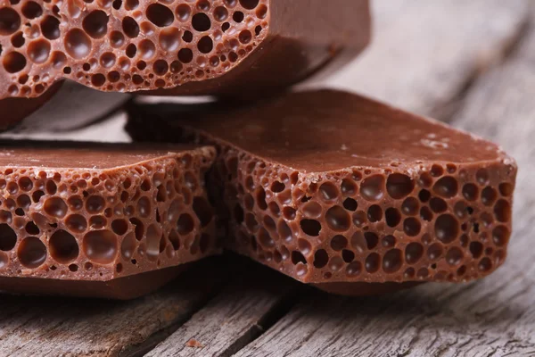 Chocolate marrón poroso en el primer plano de la mesa de madera vieja . —  Fotos de Stock