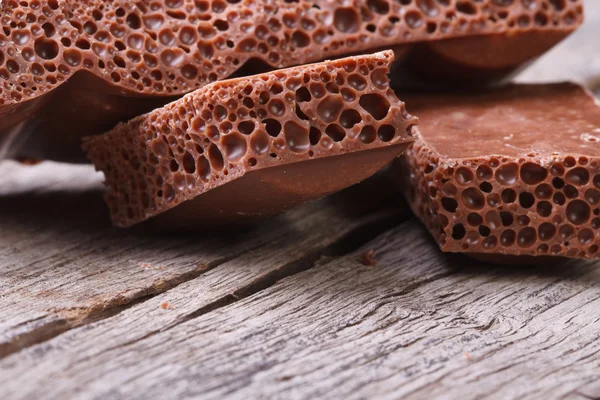 Pile of porous chocolate on old wooden table — Stock Photo, Image