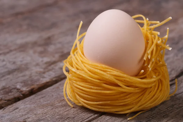 Dried pasta in the shape of the nest with chicken eggs — Stock Photo, Image