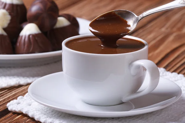 Sked av choklad som hälls i en kopp närbild — Stockfoto