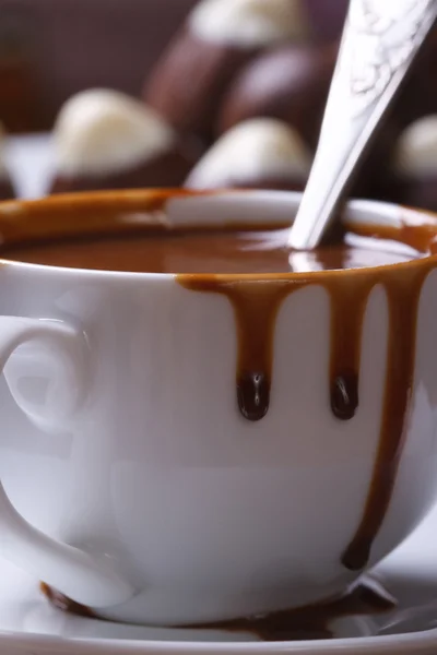 Жидкий горячий шоколад выплескивается из чашки крупным планом вертикально — стоковое фото