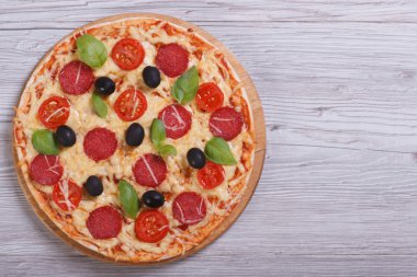 Bütün pizza salam, domates, peynir, zeytin, fesleğen ile