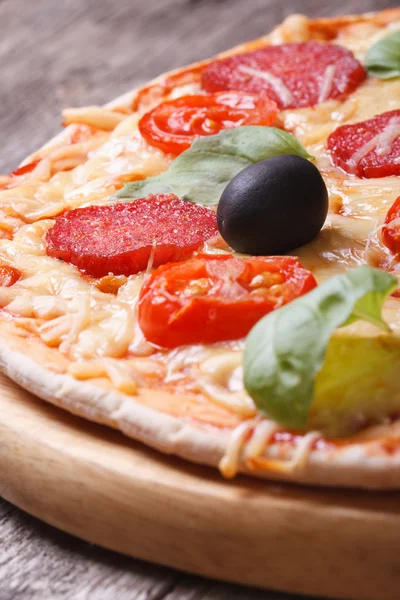 Pizza con salame primo piano sul tavolo. verticale — Foto Stock