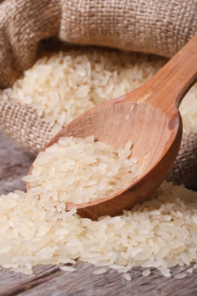 Derrame macro de arroz seco de la bolsa sobre la mesa — Foto de Stock