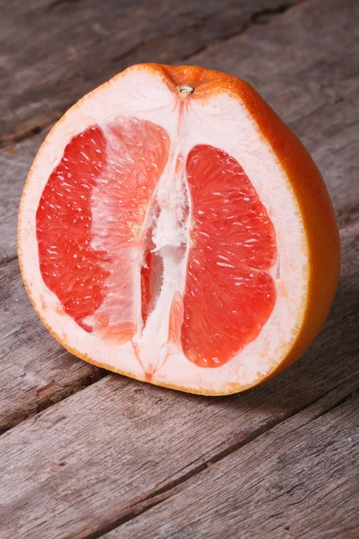 Sliced ripe grapefruit on an old wooden, vertical — Stock Photo, Image