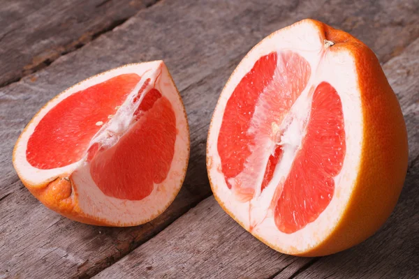 Red grapefruit cut on the old wooden table — Stock Photo, Image