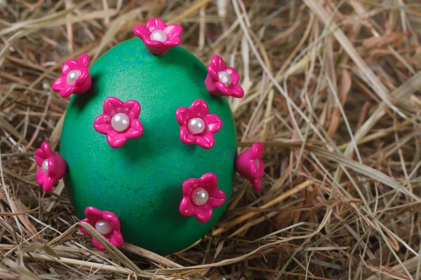 Green easter egg decorated with pink flowers — Stock Photo, Image