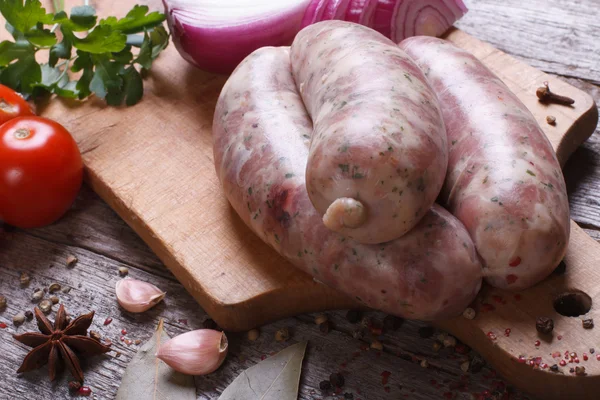 Grelha de salsicha crua com ingredientes e especiarias close-up — Fotografia de Stock