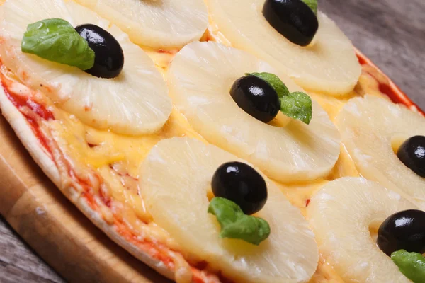 Pizza with pineapple and black olives on the old table — Stock Photo, Image