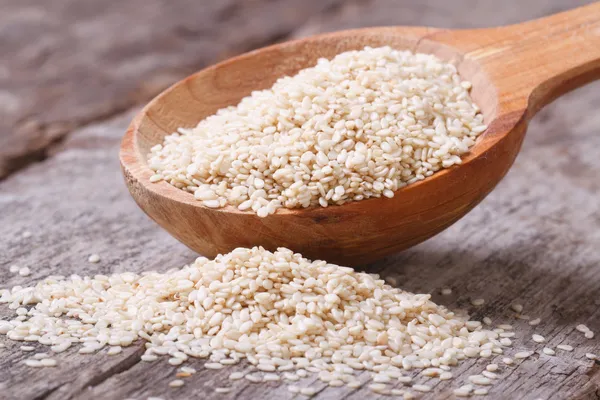 Sesame seeds in a wooden spoon closeup — Stock Photo, Image