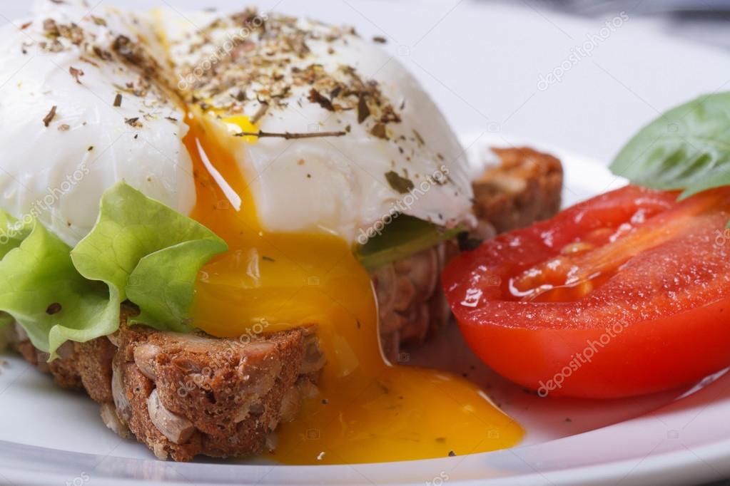 open poached egg, tomato and bread