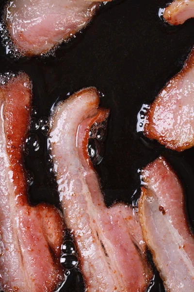 Bacon stekning i stekpanna vertikala. makro — Stockfoto