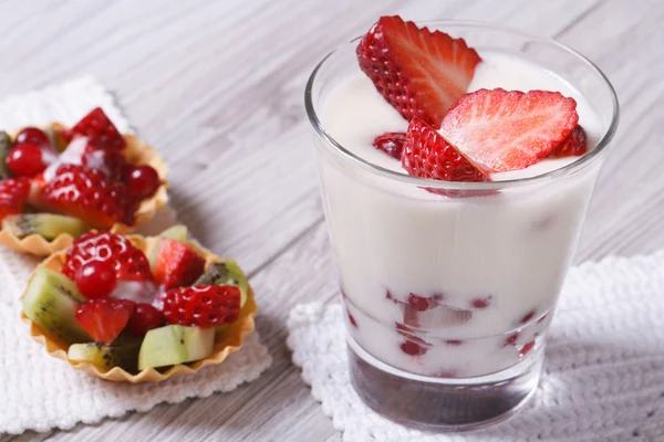 Yogurt with fresh strawberries and fruit tartlets closeup — Stock Photo, Image