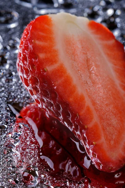 La mitad de fresas frescas con gotas de agua verticales —  Fotos de Stock